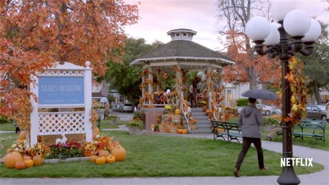 Stars Hollow town square decorated with pumpkins and autumn leaves for a festival.